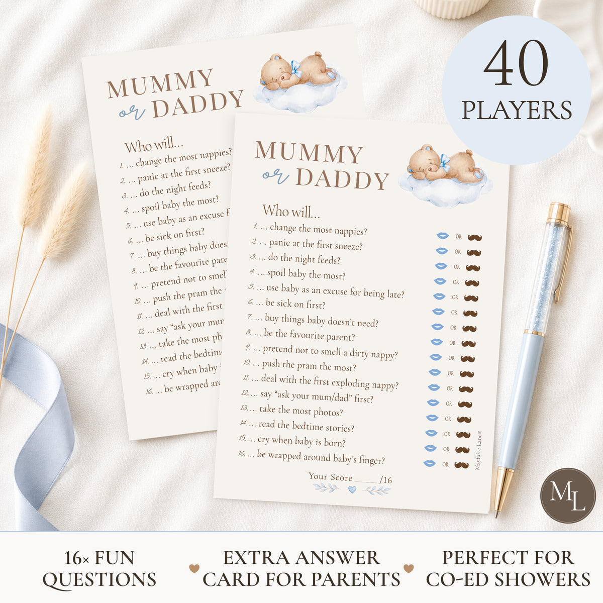 Two printed 'Mummy or Daddy' game cards laid on a white fabric surface with a blue ribbon, a pen, and a small teddy bear illustration. A circular badge says '40 PLAYERS' and the cards include a score tracker and fun questions.