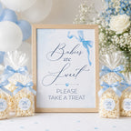 Framed sign with 'Babies are Sweet, Please Take a Treat' text, surrounded by popcorn bags and balloons.