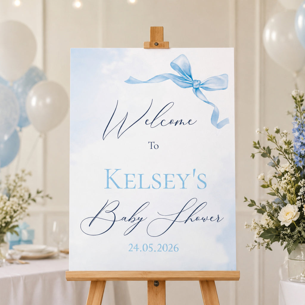 Little Bow Blue personalised baby shower welcome sign with blue bow design displayed on wooden easel for baby boy baby shower venue entrance.