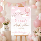 Personalised Up and Away Baby Girl baby shower welcome sign featuring pink hot air balloons, clouds and a custom name displayed on an easel at a pink baby shower venue.