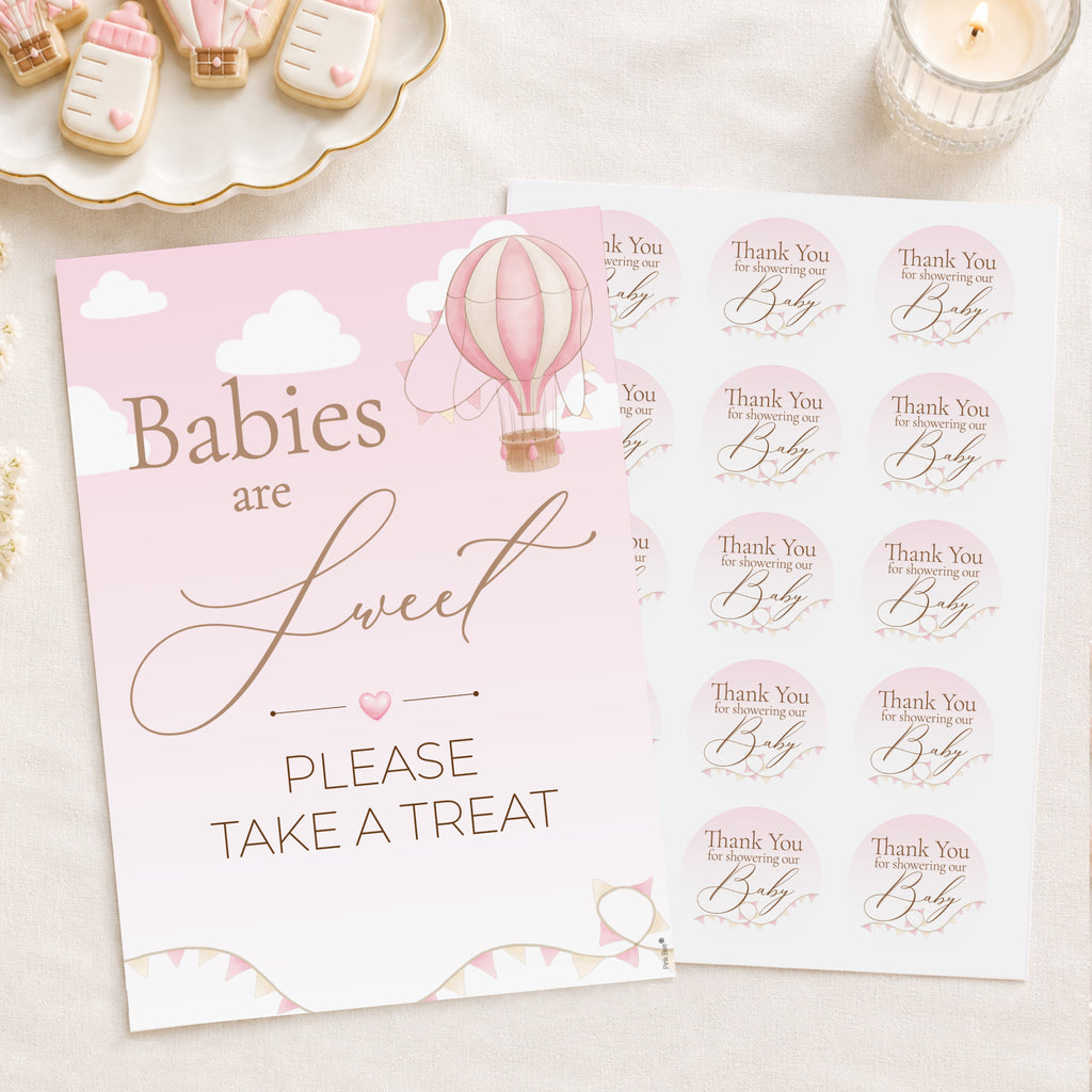 Pink and white baby shower sign and matching sticker sheet with hot air balloon and cursive text reading 'Babies are Sweet PLEASE TAKE A TREAT' on a light fabric background.