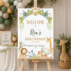 A personalized baby shower welcome sign displayed on a wooden easel in a styled nursery setting. The sign features a white background with a watercolor jungle and safari theme, including green leaves, a gold crown, and cartoon animals like a lion, giraffe, elephant, and rhino.