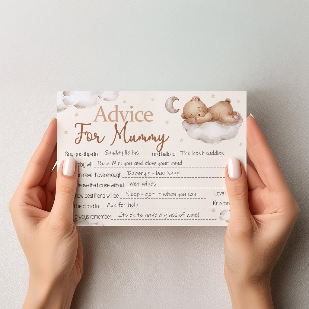 A person holds a printed 'Advice For Mummy' baby shower card against a plain light gray background. The card has a soft cream background with brown text, illustrated sleeping baby bears on clouds, and a crescent moon.