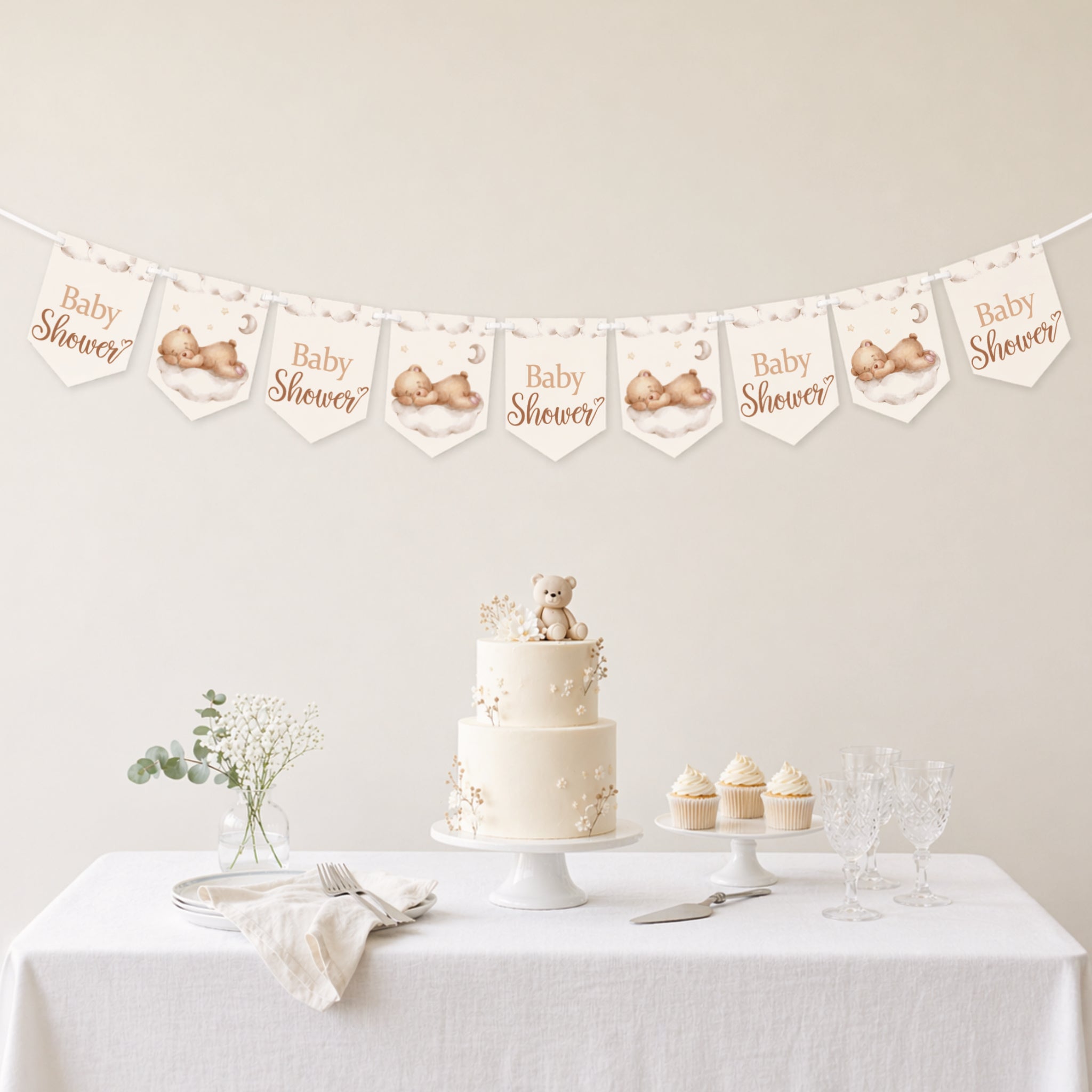 Teddy bear baby shower banner bunting displayed above a neutral baby shower dessert table with teddy cake and cupcakes.