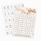 Baby Bingo game set with a beige and pink bingo card featuring a sleeping teddy bear illustration, plus matching blank cards and a scoring grid on a white background.