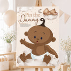 A2 Ethnic Teddy Bear Pin the Dummy baby shower game displayed on an easel with teddy bear themed party decorations.