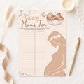 Neutral teddy bear Guess Mum's Tum baby shower game displayed on soft cream fabric with pen.