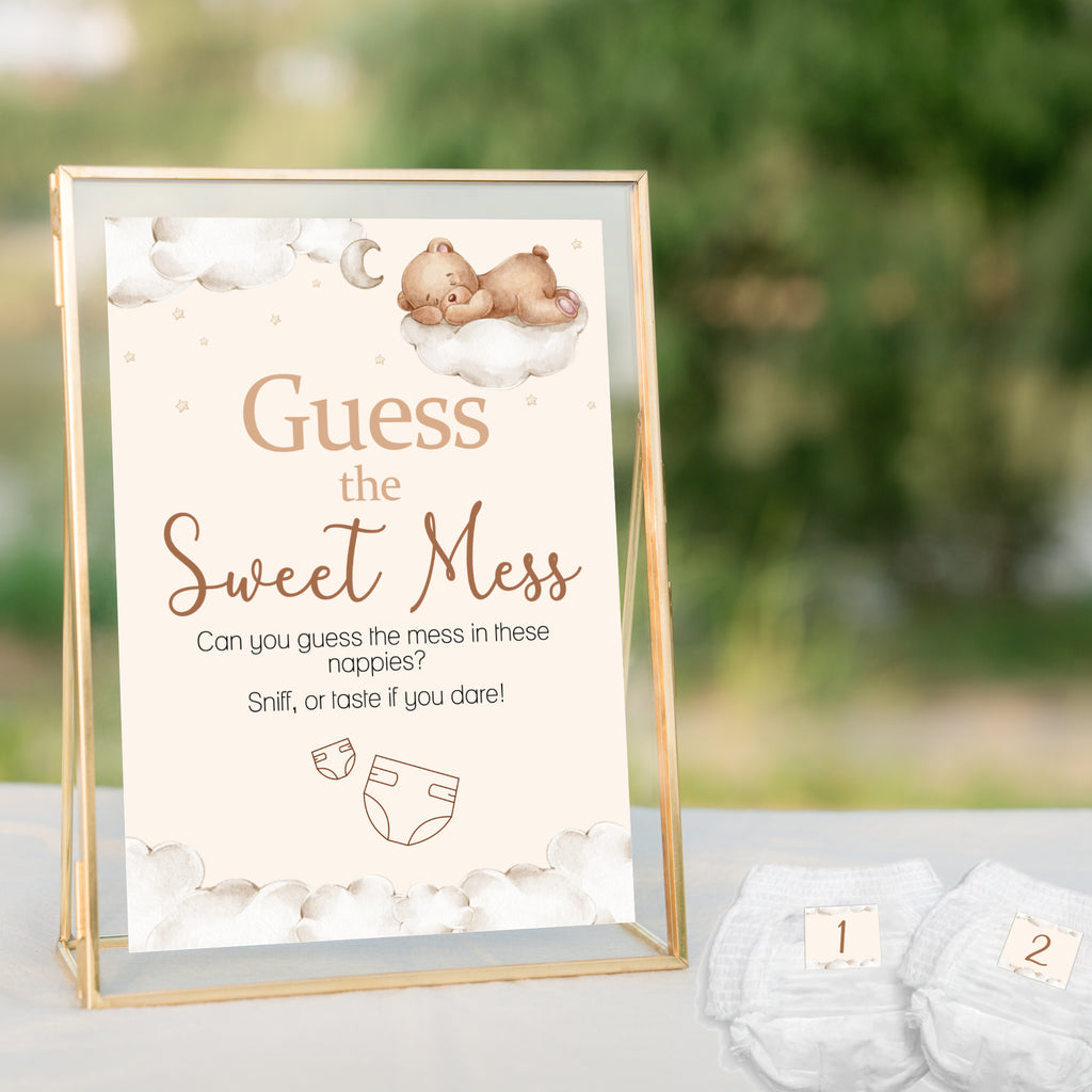 Teddy Bear Guess the Sweet Mess baby shower sign displayed in a gold frame beside numbered nappies for a neutral teddy themed baby shower.