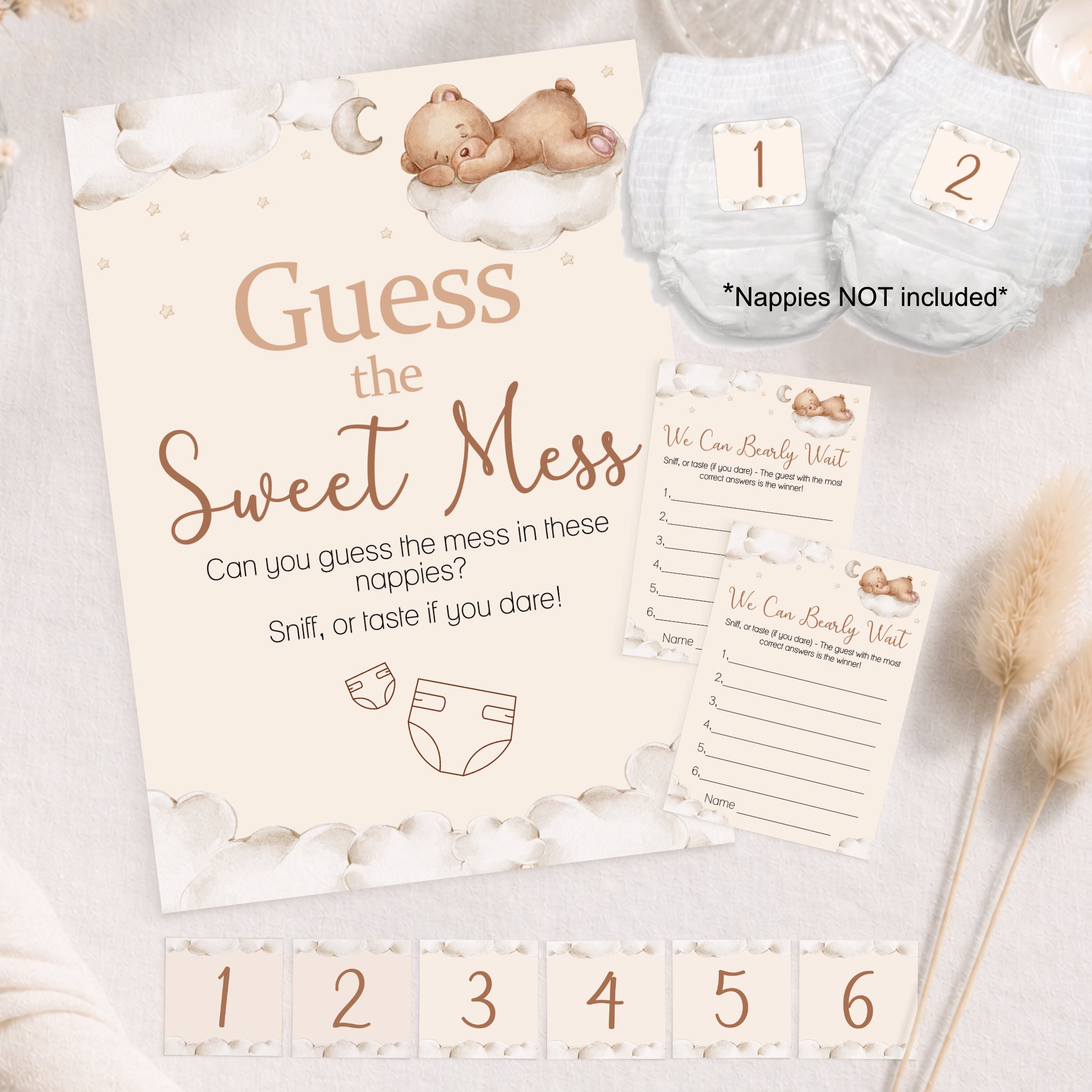 Flat lay Teddy Bear Guess the Sweet Mess baby shower game with A4 sign, guest cards, numbered nappies and stickers.
