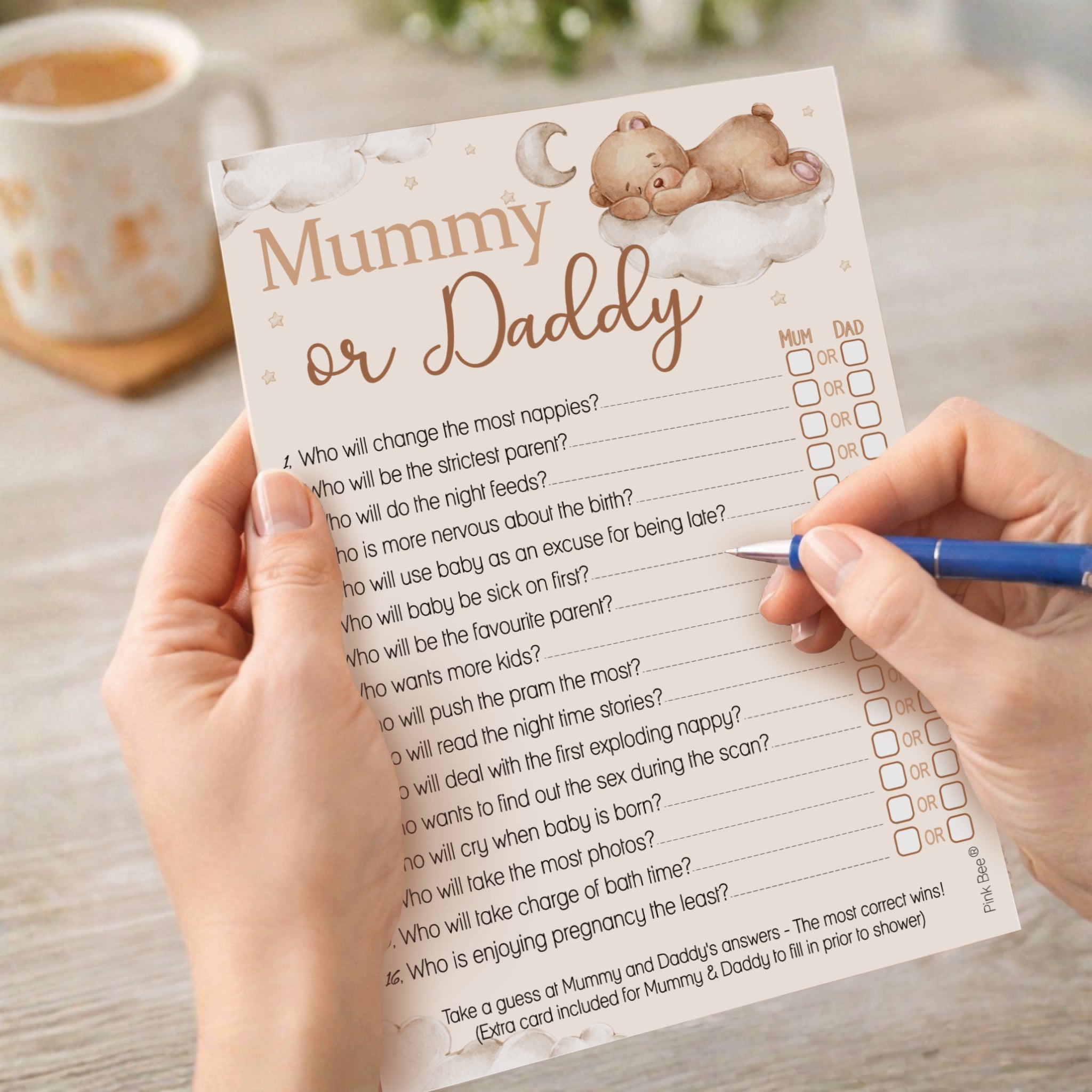 Guest completing Teddy Bear Mummy or Daddy baby shower game card during a baby shower celebration.
