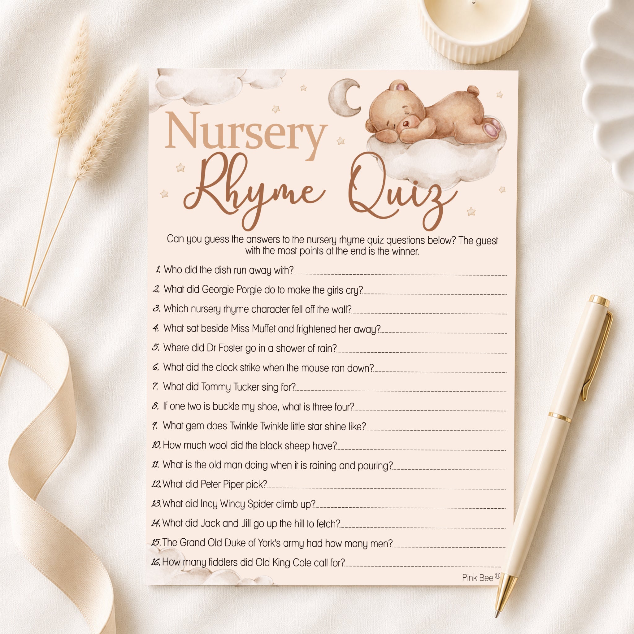 Teddy Bear Nursery Rhyme Quiz baby shower game card displayed on a neutral baby shower flat lay with pen.