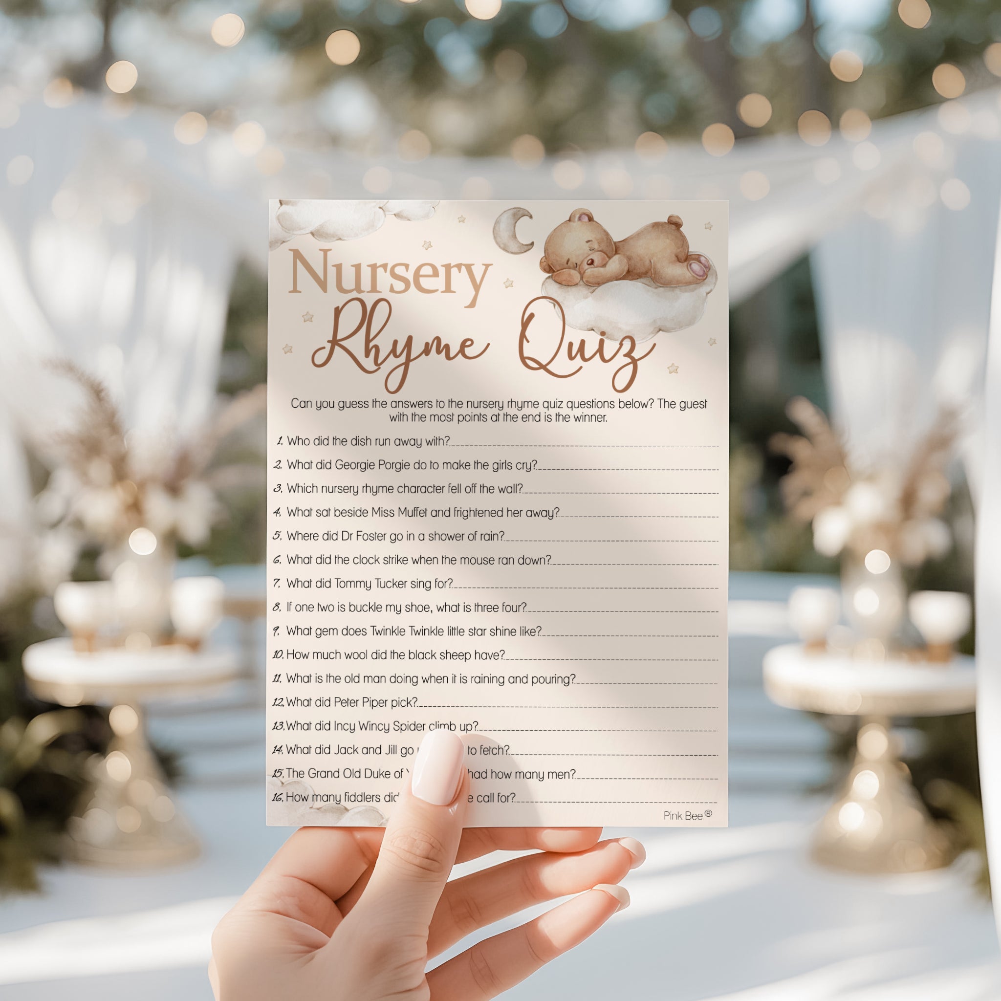Guest holding Teddy Bear Nursery Rhyme Quiz card at a teddy bear themed baby shower celebration.